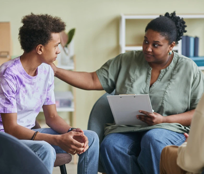 African,Young,Psychologist,Talking,To,Teenage,Boy,During,Therapy,Session
